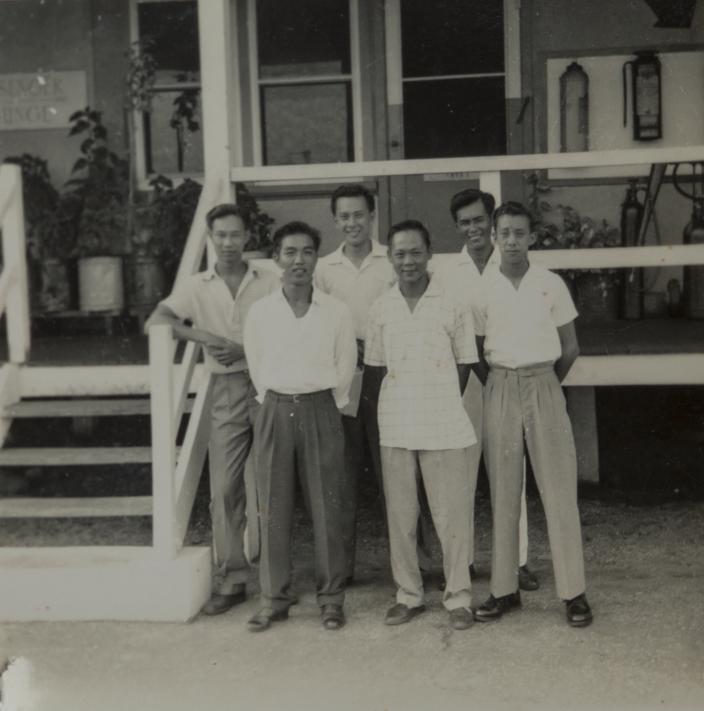 Group of men standing outside a building. 