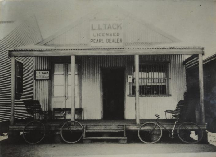 A black and white shop front with bicycles out the front. 