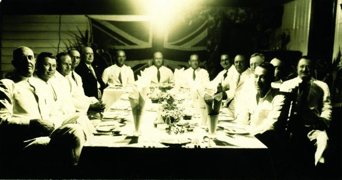A group of men sitting around a table. 