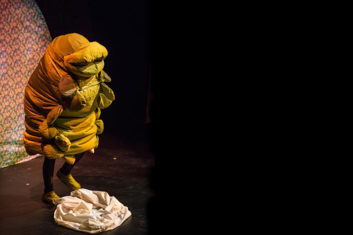 Man in a caterpillar suit on stage