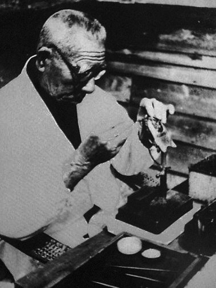 A man working with a pearlshell. 