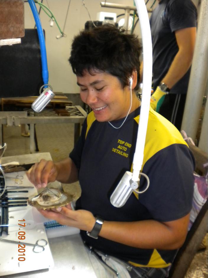 Image of a person working with a pearlshell. 