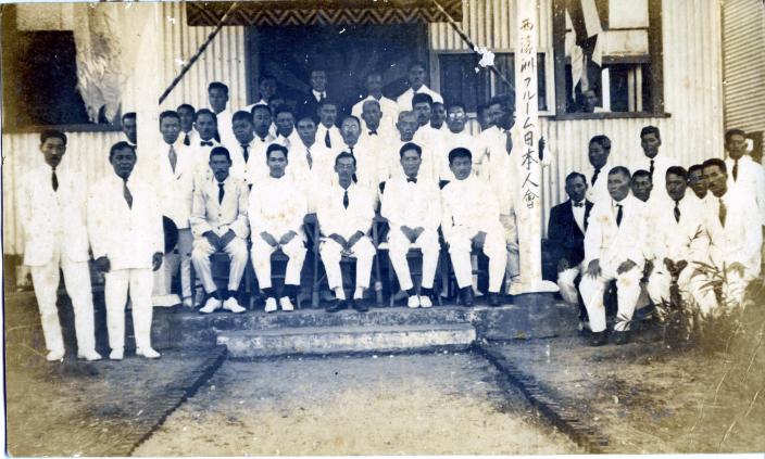A group of people sitting outside a club. 