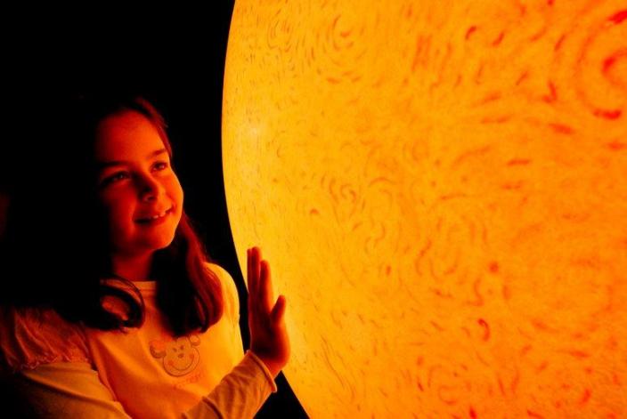 Young girl with Sun replica at the Diamonds to Dinosaurs Gallery, WA Museum - Pe