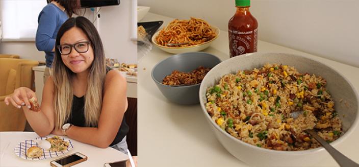 Woman sits eating fried rice, bowl of fried rice and hot sauce.