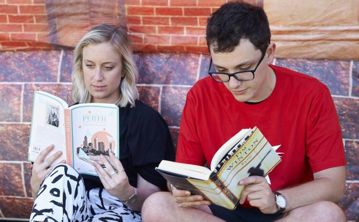 "A man and a woman reading Western Australian literature outside the Inflatable Museum."