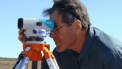 Dr Bill Humphreys measuring the landscape with a surveying tool
