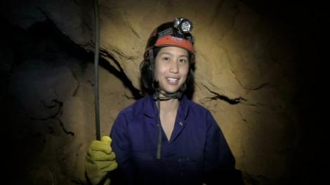 A lady descending into a cave