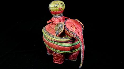A basket designed to look like the body of an elephant with a rider perched atop