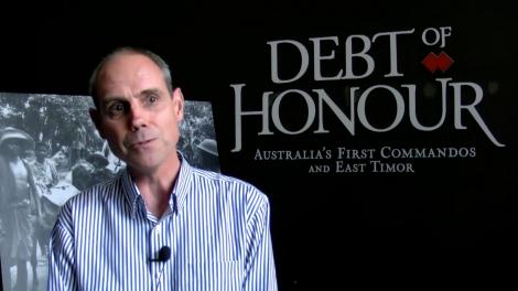 Stephen Anstey standing in front of entry to the exhibition Debt of Honour