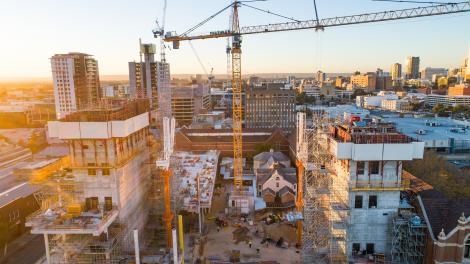 New Museum building site with crane in the middle, the sun is rising to the left side of the picture and the image has hues of blue and pink from the sunrise