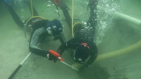 Two divers excavating an underwater wreck location