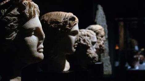 Ancient Greek stone statue busts on display in a museum