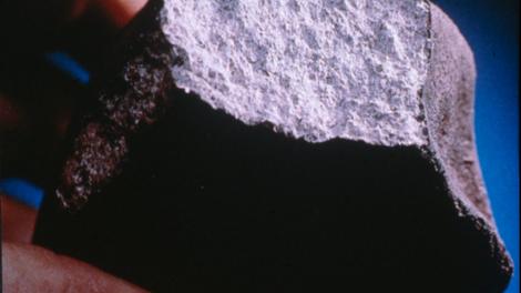 A scientists examining a meteorite close-up