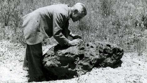 A scientists examining a meteorite in the field