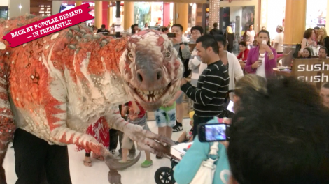 A giant dinosaur puppet walking around Garden City mall