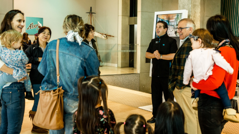A group of visitors listening to a Museum staff member.