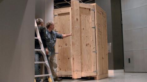 Two people working on opening an exhibition storage case
