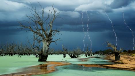 A dramatic storm taking place over a stark Australian outback lanscape