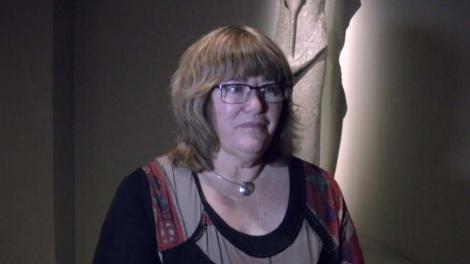 Dr Moya Smith standing in front of a Egyptian statue