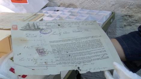 Document found in the shipwreck of the Sepia being held by white gloves