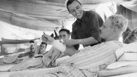 Nurse treating a patient in a tent hospital