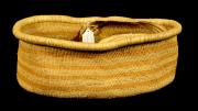 An open, oval shaped, single handled basket with yellow vegetable dye stripes.