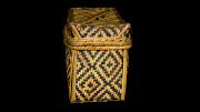 A lidded, rectangular, black and natural coloured basket  with a diamond design.