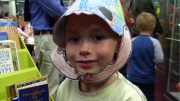 Child wearing dinosaur mask