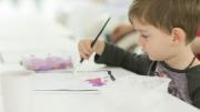 Child painting a collage in the Museum of Us