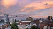 the pink sky of a sunset behind the heritage buildings of the new museum site 