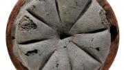 "A round black loaf of carbonised bread. It had been marked to be cut into eight triangles."