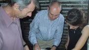 Image of three people inspecting a box containing clear plastic bags