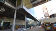 A dirt floor in the foreground gives way to the concrete interior of a building in construction.