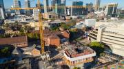 large yellow crane with it's long arm high above construction site