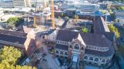 Two Victorian era buildings sit side by side with pathway to construction between them