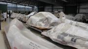 Large bones sit on pallets wrapped in plastic in a warehouse.