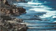 A rugged coastline with waves breaking on the shoreline