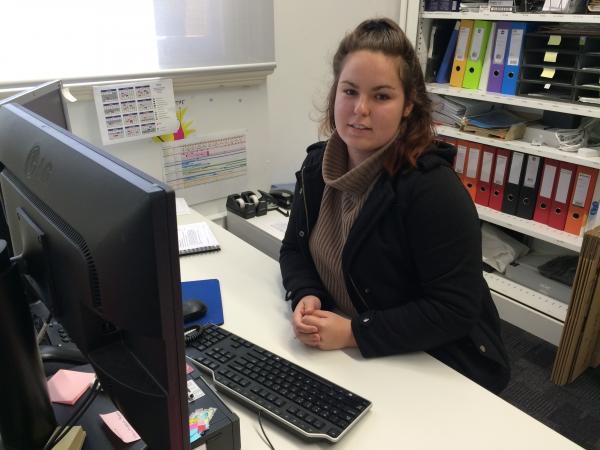 Caitlin Bonfield sitting at her desk
