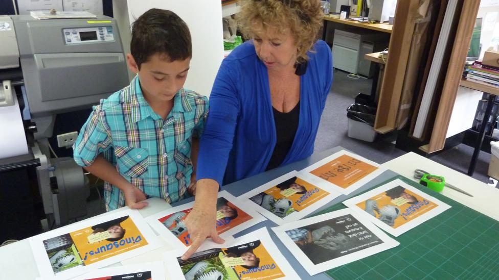 A child and adult looking through a series of advertisements
