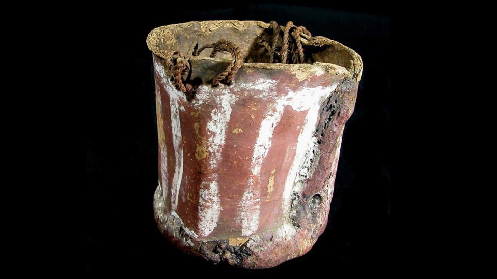 A bucket constructed out of bark and painted