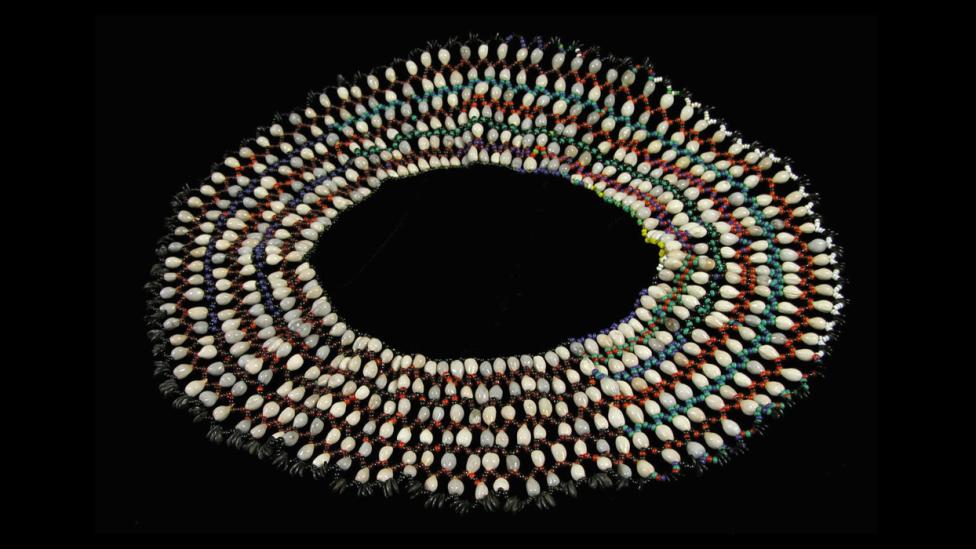 Woven necklace of seashells arranged for a photo