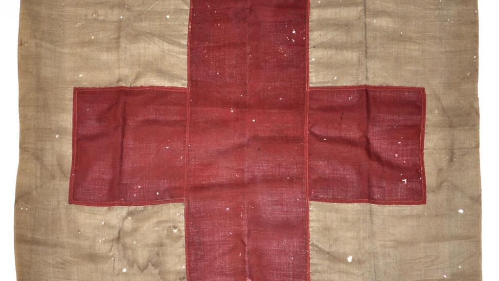 "100 year old flag with red cross symbol."