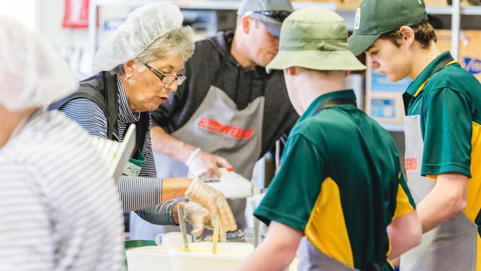 Young and older volunteers working at the catering station