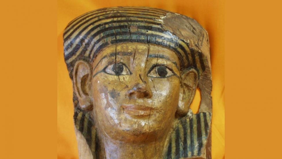 A painted ancient Egyptian coffin mask, the mask has slightly weathered over time