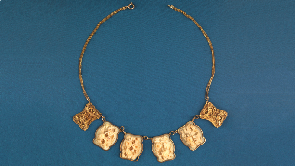 "A gold and ivory necklace."
