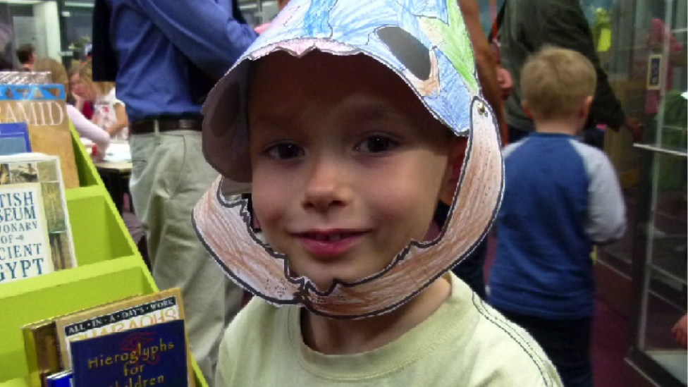 Child wearing dinosaur mask