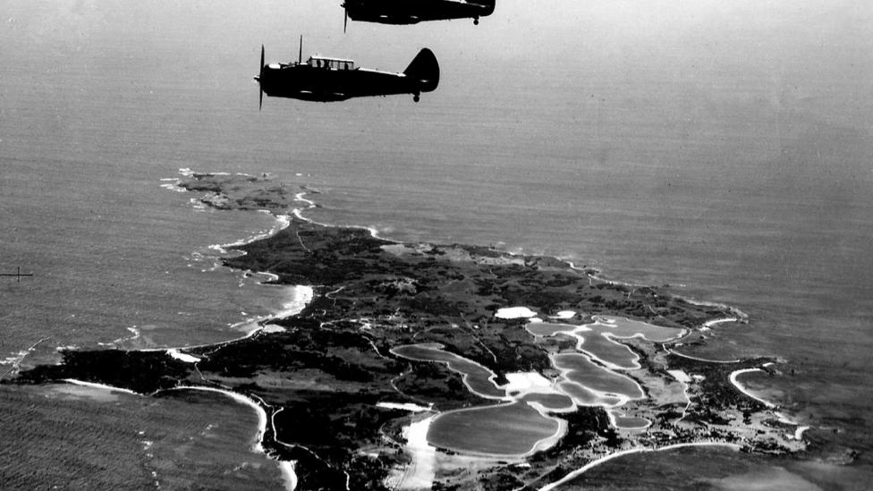 Black and white image of planes flying over an island