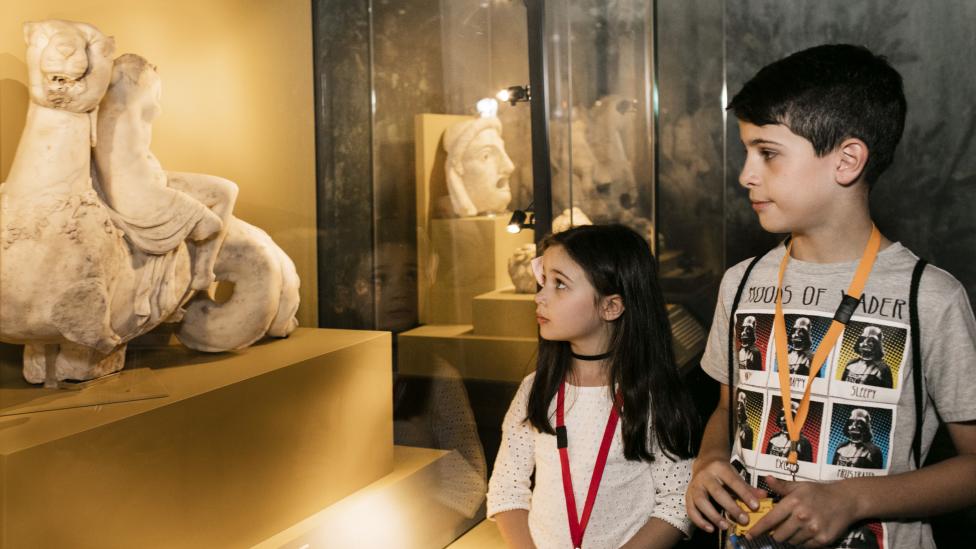 "Two children look at an artefact from the exhibition with great curiosity."
