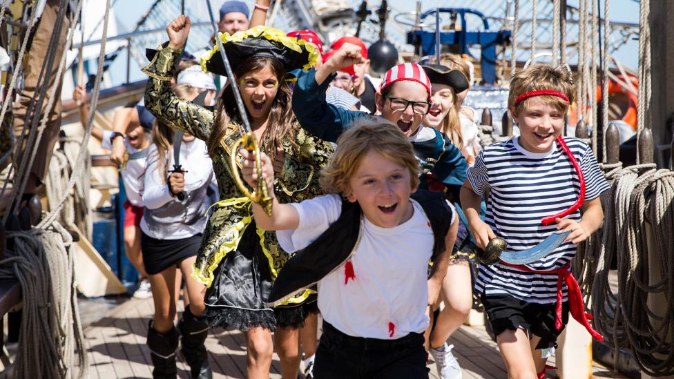 "A crew of perilous pirates run across the deck of a ship."